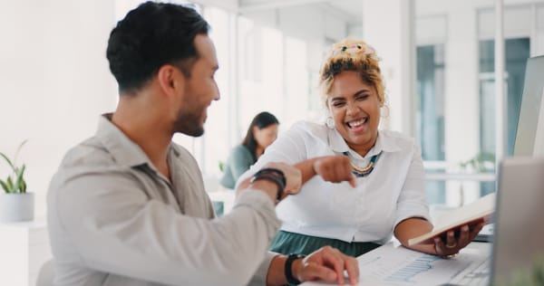 Two engaged employees fistbump