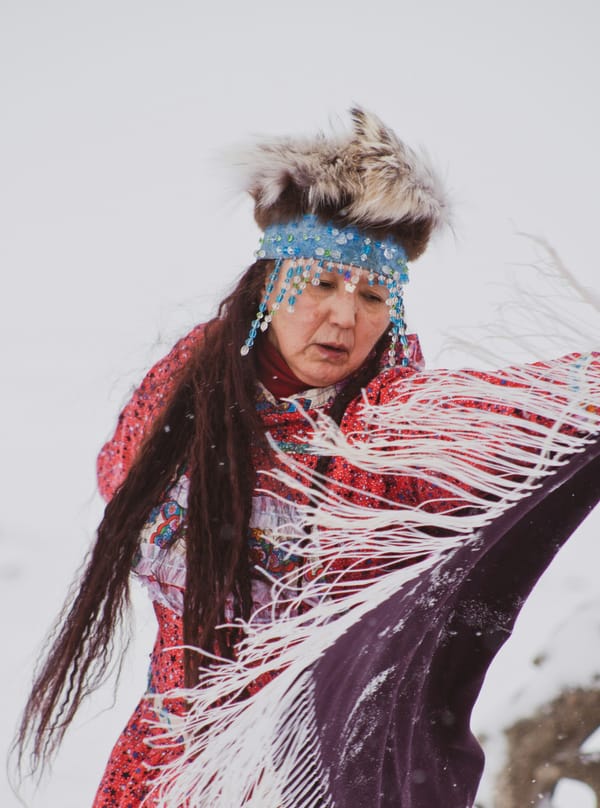 A Native American person dances in traditional clothing
