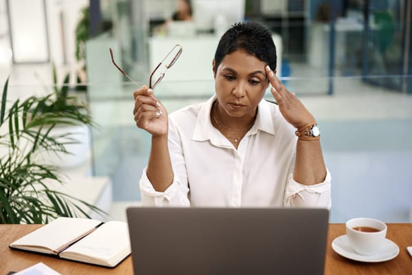 An employee looks anxious about AI on her laptop
